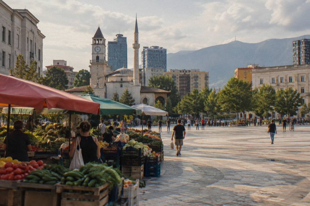 Fruit and vegetable stalls with colourful awnings at an outdoor market in Tirana