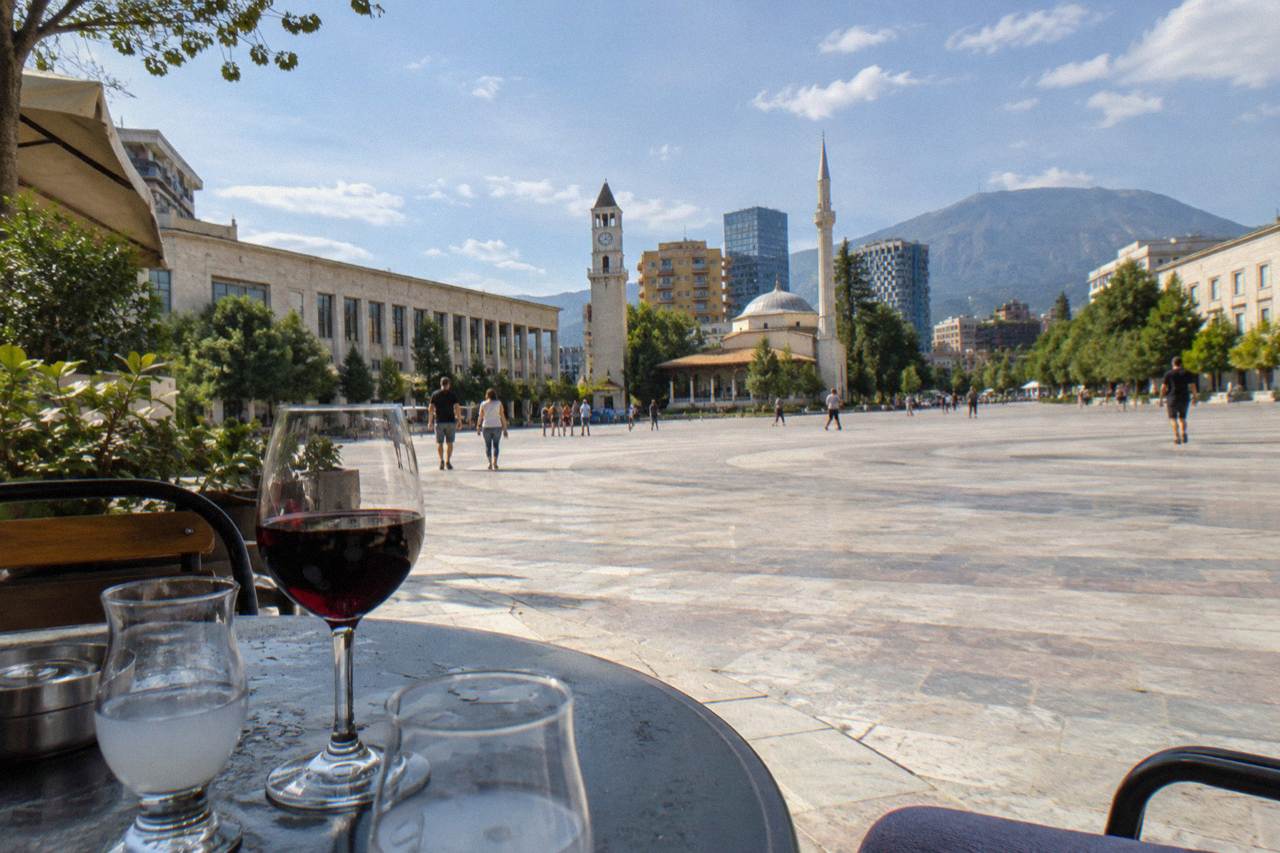 Glasses of raki and red wine on a cafe table in a Tirana street