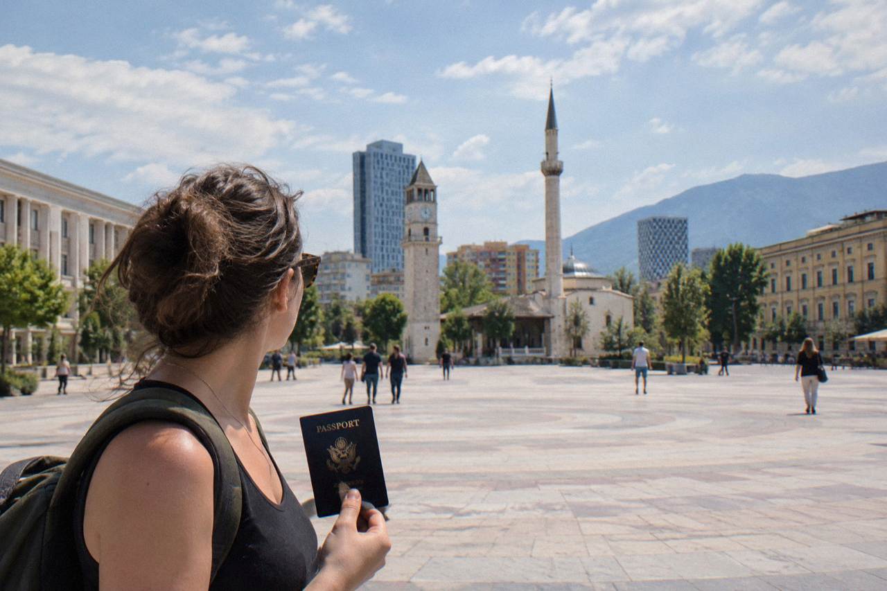 A traveler holding an American passport outside a government building in Tirana