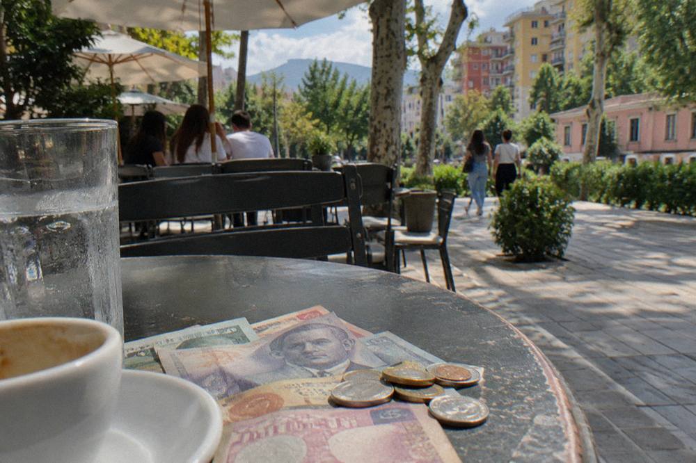 Close-up of Albanian lek banknotes and coins left on a cafe table