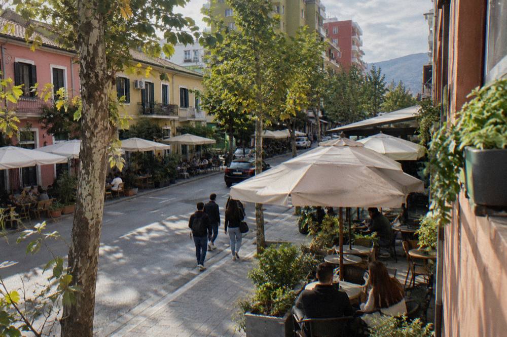 Colourful facades and cafe tables on a street in the Blloku quarter of Tirana