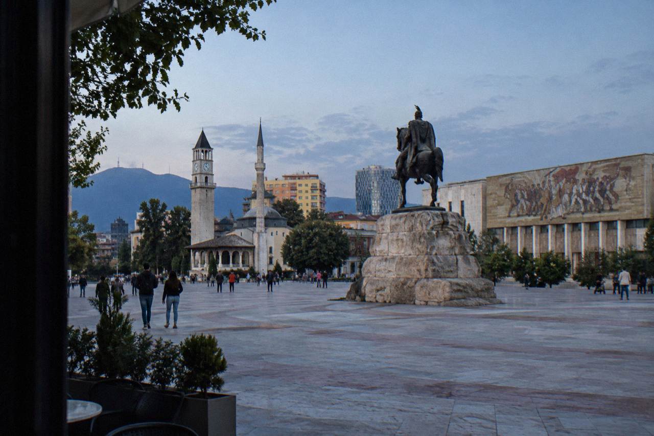 Skanderbeg Square in Tirana with the equestrian statue and the mosaic museum facade under a clear sky