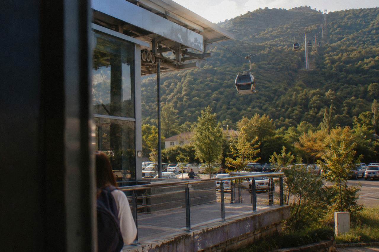 A cable car cabin travelling up the green slopes of Mount Dajti above Tirana