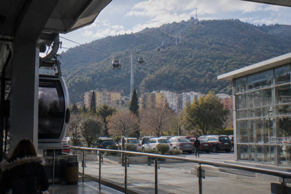 Cable car cabins rising through forest toward the top of Mount Dajti above Tirana