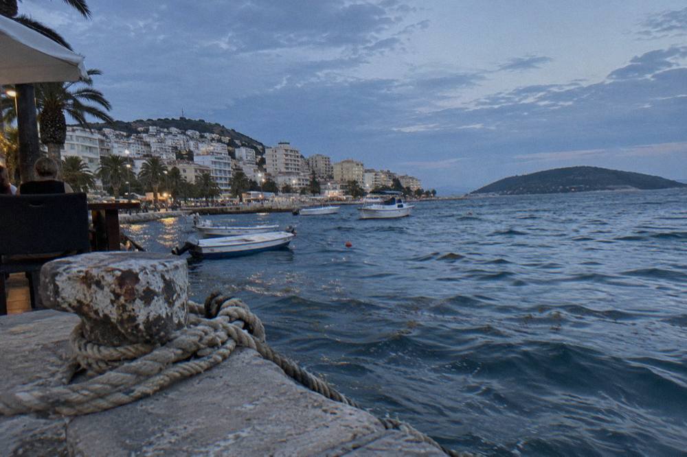 The Ionian seafront at Saranda curving along the bay with boats near the shore