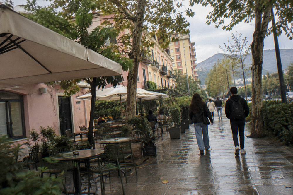 A lively quarter of former villas turned cafes, tree-lined streets, outdoor chairs under plain umbrellas and low pastel-painted houses
