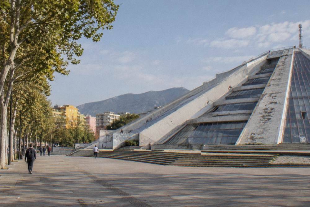 The stepped glass-clad surfaces of the Pyramid of Tirana under a clear sky