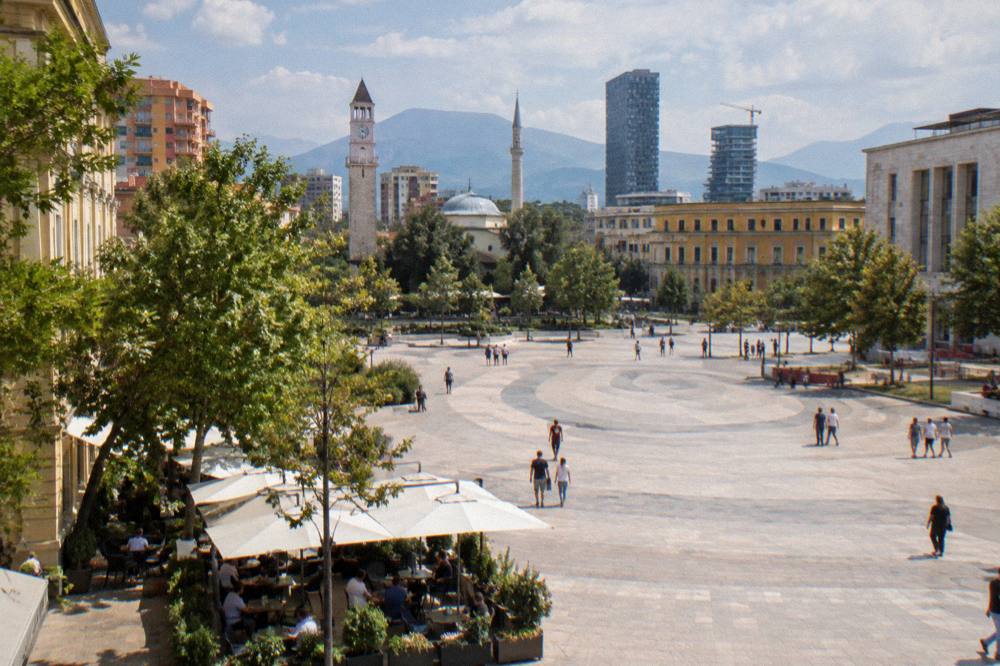 Cafe tables and leafy trees on a pedestrian street in central Tirana