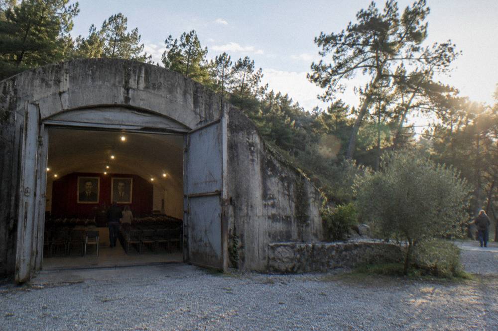 A preserved assembly hall inside the bunker with rows of chairs and period portraiture on the wall