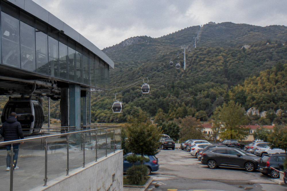 Cable car cabins of the Dajti Ekspres rising above forest on the slopes of Mount Dajti above Tirana