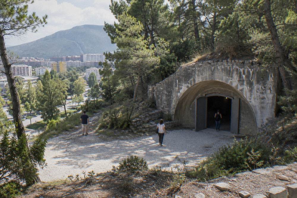 Museum exhibit room with photographs and artefacts inside a concrete bunker