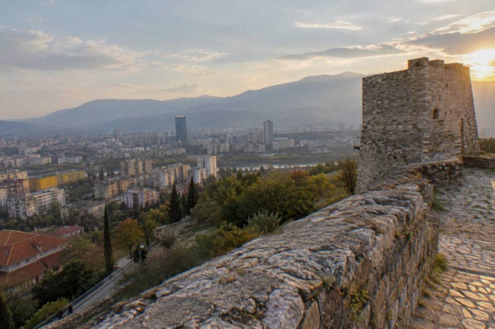 Hilltop castle walls above a valley landscape near Tirana at golden hour