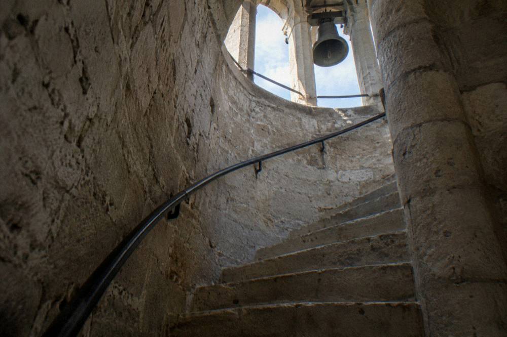 The narrow spiral stone staircase inside the Clock Tower of Tirana seen from below