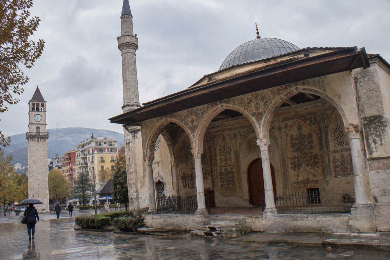 The frescoed porch and closed wooden doors of the Et'hem Bey Mosque beside the Clock Tower in Tirana