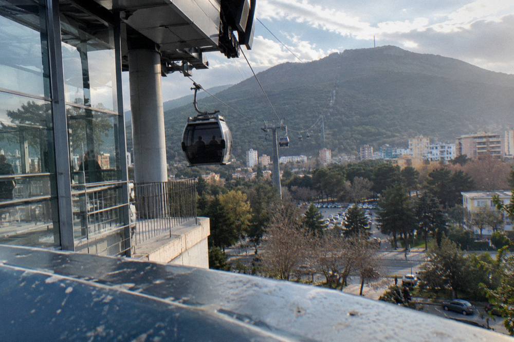 Cable car descending toward Tirana in late afternoon light