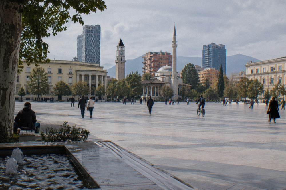 Bronze statues of workers and partisans standing among trees in a park in central Tirana