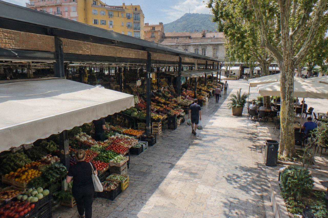 Market stalls with fresh produce under a covered walkway in the New Bazaar area of Tirana