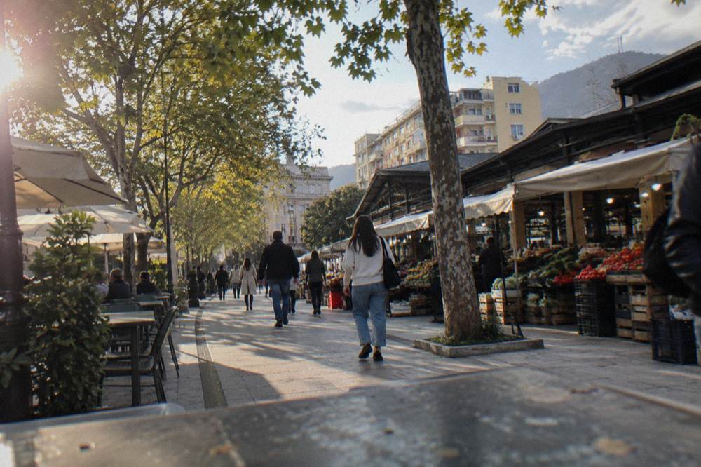 People walking along a tree-lined street between Skanderbeg Square and the New Bazaar in Tirana
