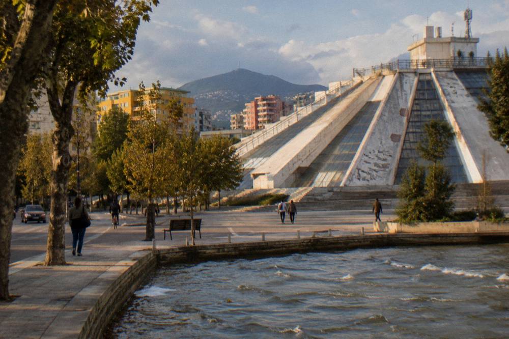 The renovated Pyramid of Tirana with its stepped exterior under a blue sky