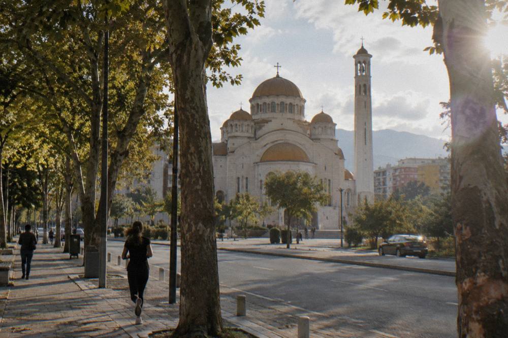 The cathedral facade seen from a tree-lined street south of Skanderbeg Square
