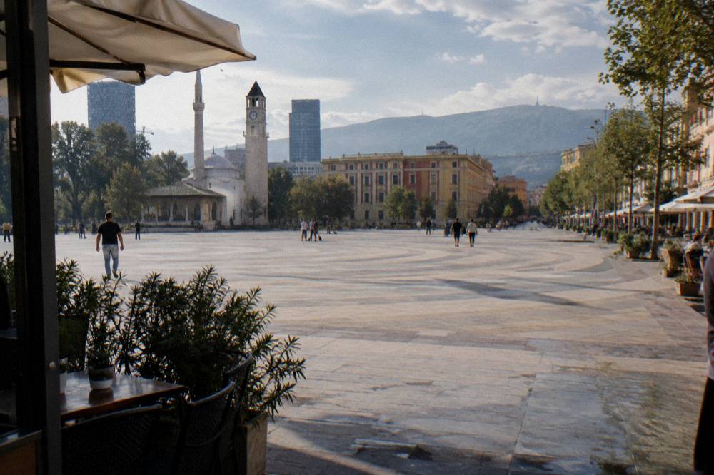 A street of cafes and pastel buildings leading away from the square