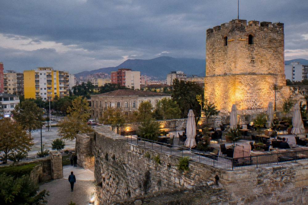 A stone tower of the castle lit warmly against a darkening sky