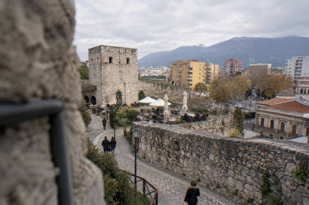 Wide view of the castle enclosure with the pedestrian lane curving between walls