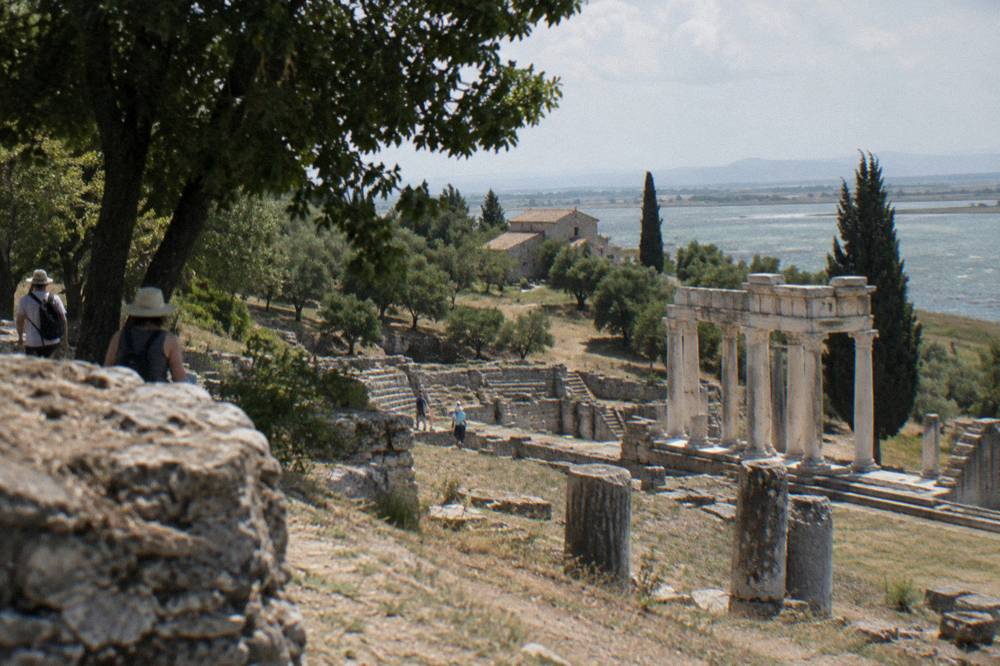 Remains of ancient stone walls and a theatre area on a quiet hillside