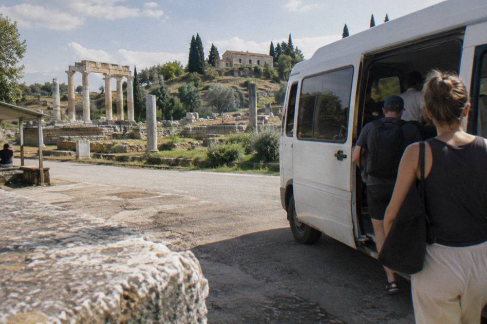 A minibus at a regional bus terminal with passengers boarding