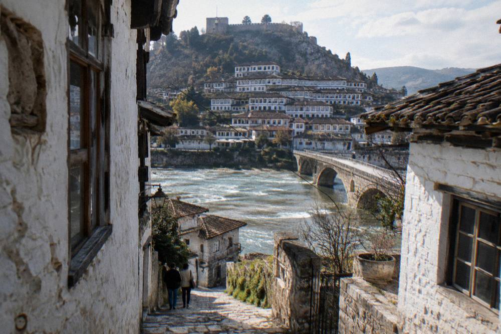 A narrow stone lane between white houses inside Berat Castle