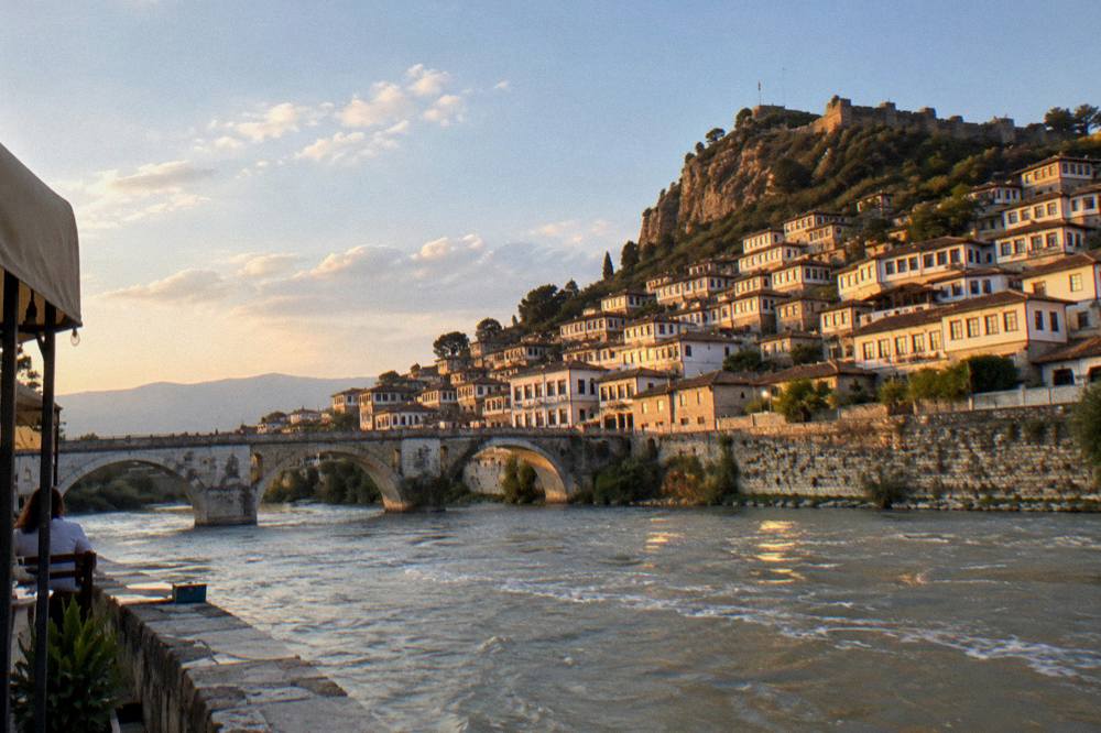 Sunset light on the white facades and windows of Berat above the river