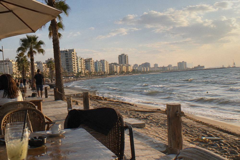 Outdoor cafe tables along the Durres seafront in late afternoon light