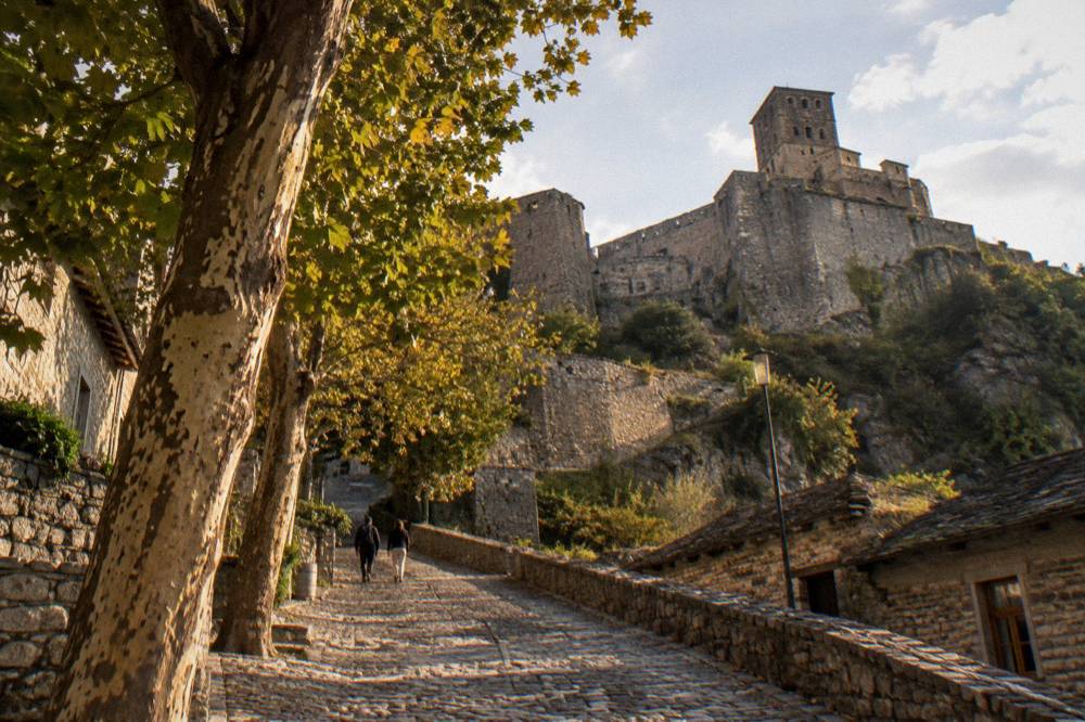 The stone walls and ramparts of Gjirokaster castle seen from a lane below