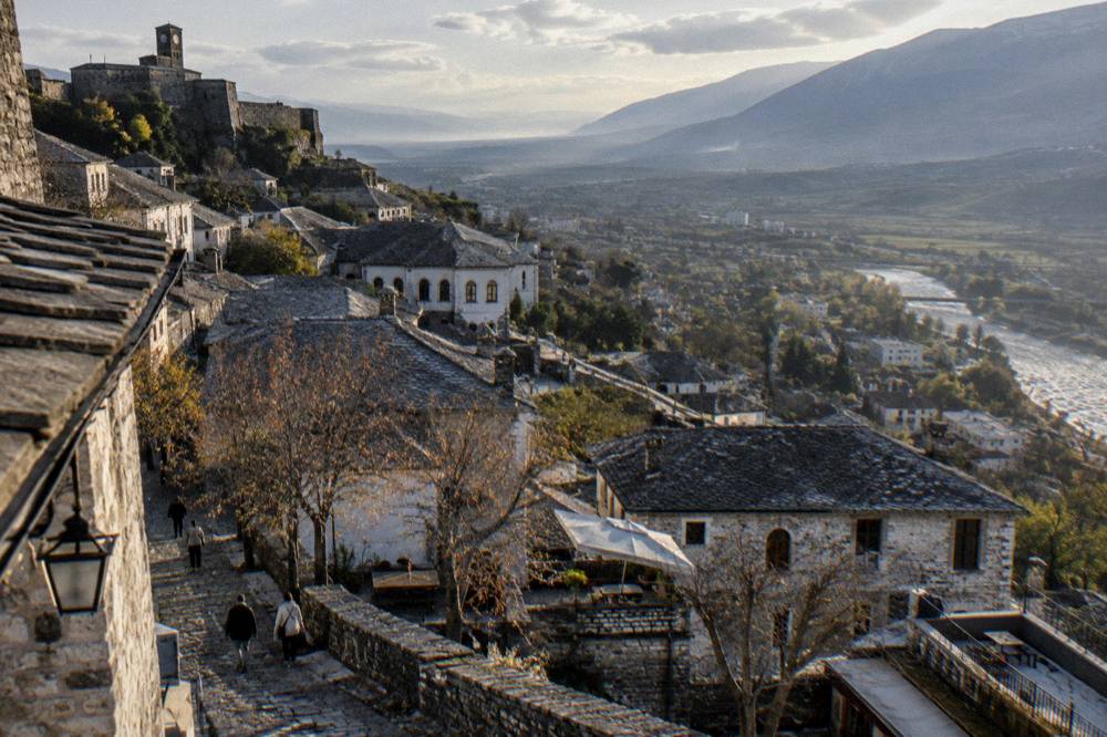 Sunset light on the grey stone roofs of Gjirokaster old town with the valley beyond