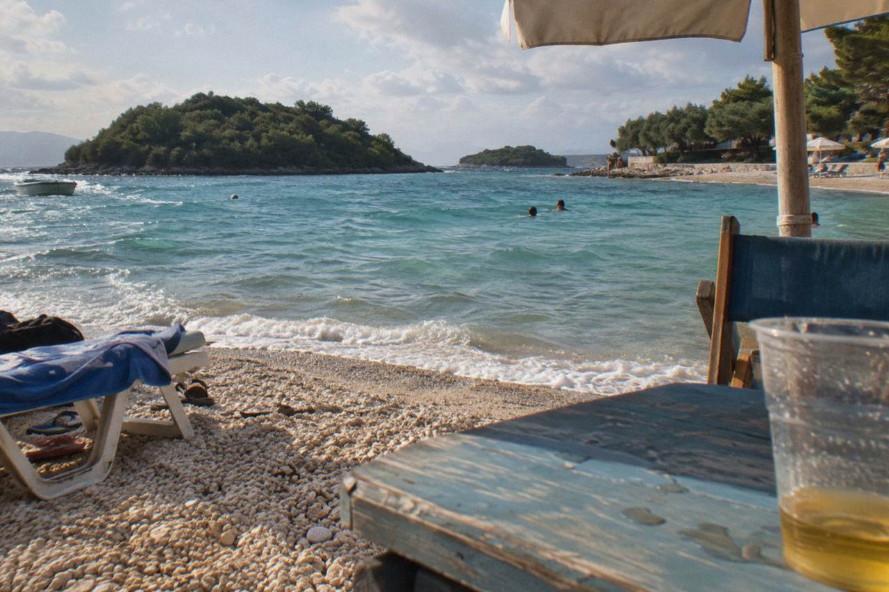 Turquoise water and small wooded islands along a sandy beach in Ksamil on the Albanian southern coast
