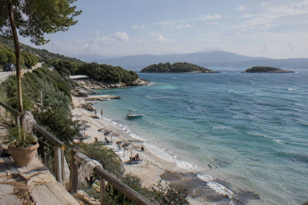 A winding coastal road above a green mountainside with sea views on the drive south from Tirana
