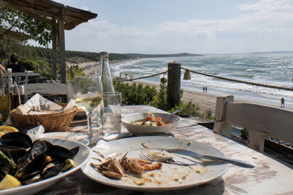 A table set for a seafood meal on a terrace overlooking the sea