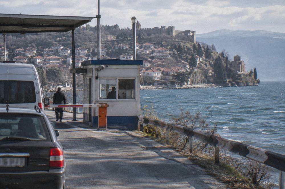 A small border checkpoint booth on a road between two countries