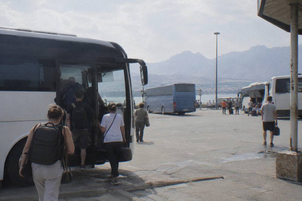 Buses parked at an intercity terminal with passengers boarding