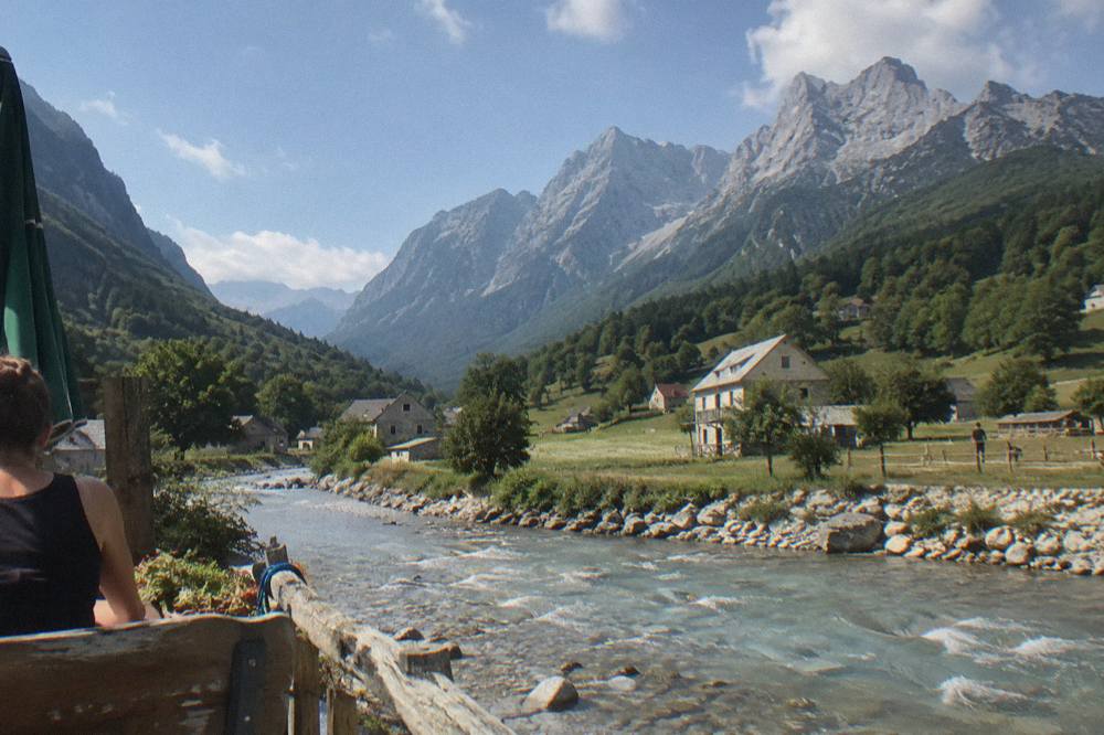 Stone village houses beneath jagged limestone peaks in morning light