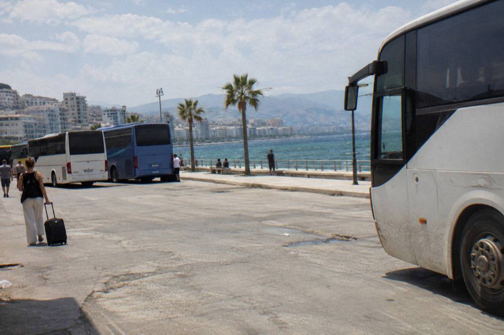 A row of regional buses parked at an open-air terminal in morning light