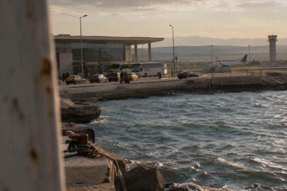 A border crossing point with booths, barriers and vehicles waiting