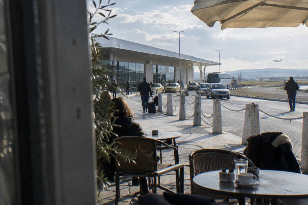 A café terrace with small tables on a sunny pedestrian street