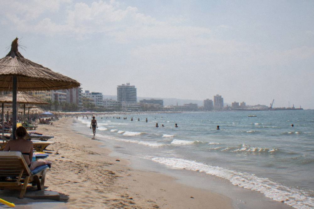 A wide sandy Adriatic beach with parasols and a calm sea at Durres