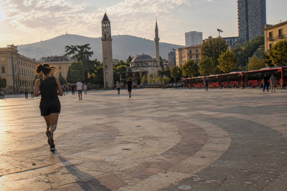 Red city buses lined up at a street terminal in Tirana