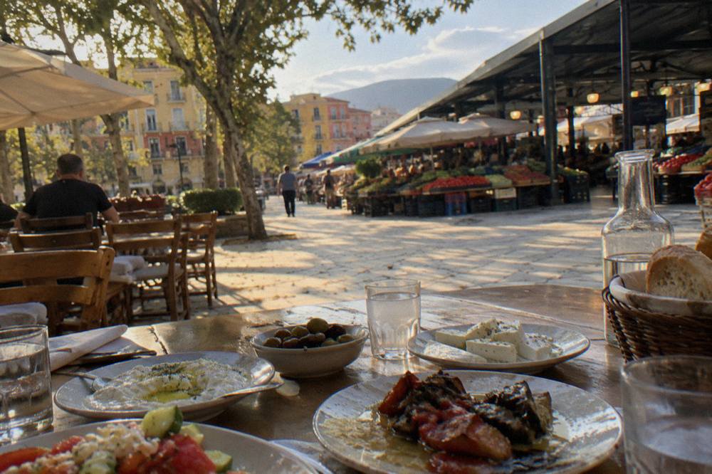 Traditional Albanian restaurant table set with mezze plates and small raki glasses