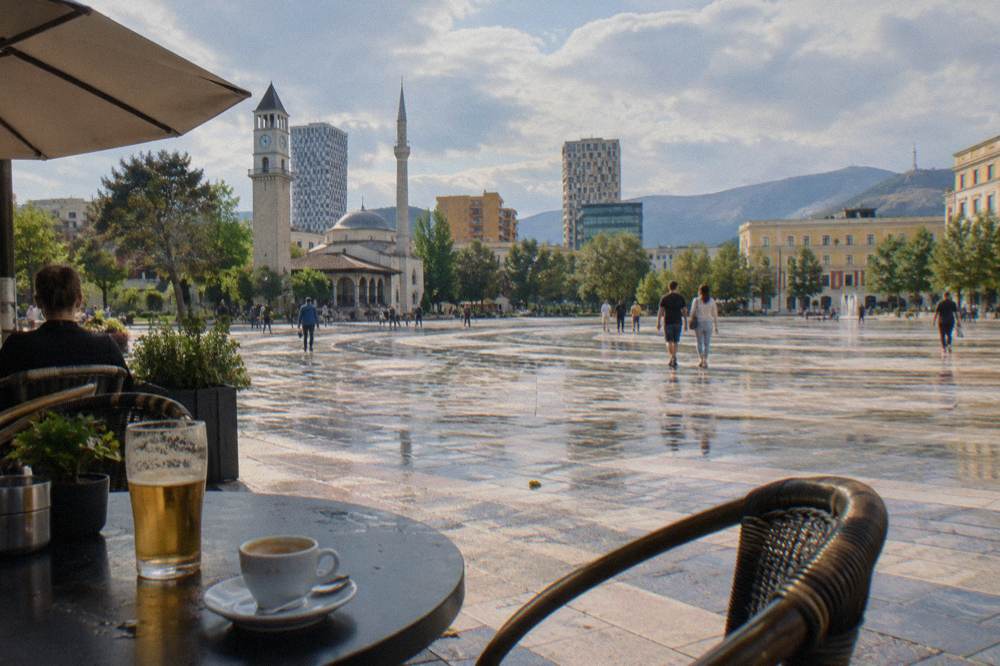 Cafe terrace in Tirana with espresso cups and a glass of beer on the table