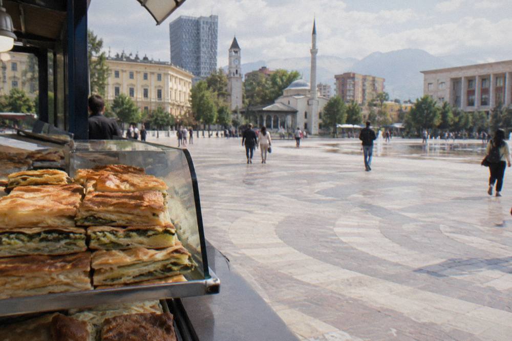 Slices of byrek pie stacked on a bakery counter in Tirana