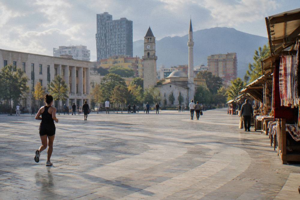 An old bazaar street with wooden stalls and hanging textiles in a hill town near Tirana
