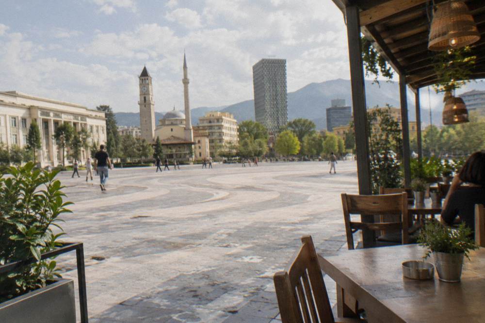 A traditional restaurant interior with wooden tables and hanging lanterns in Tirana